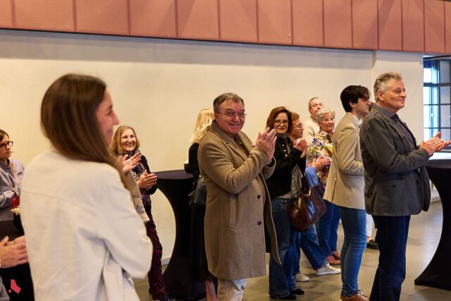 Des invité·e·s applaudissent en souriant lors de la cérémonie