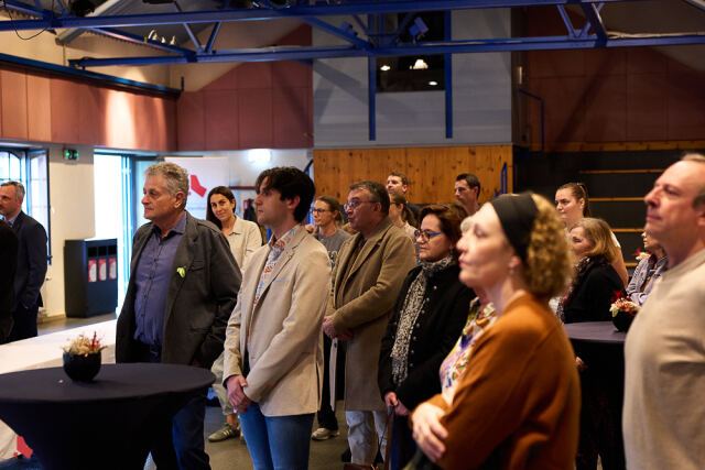 Des invité·e·s écoutent attentivement les discours lors de la cérémonie
