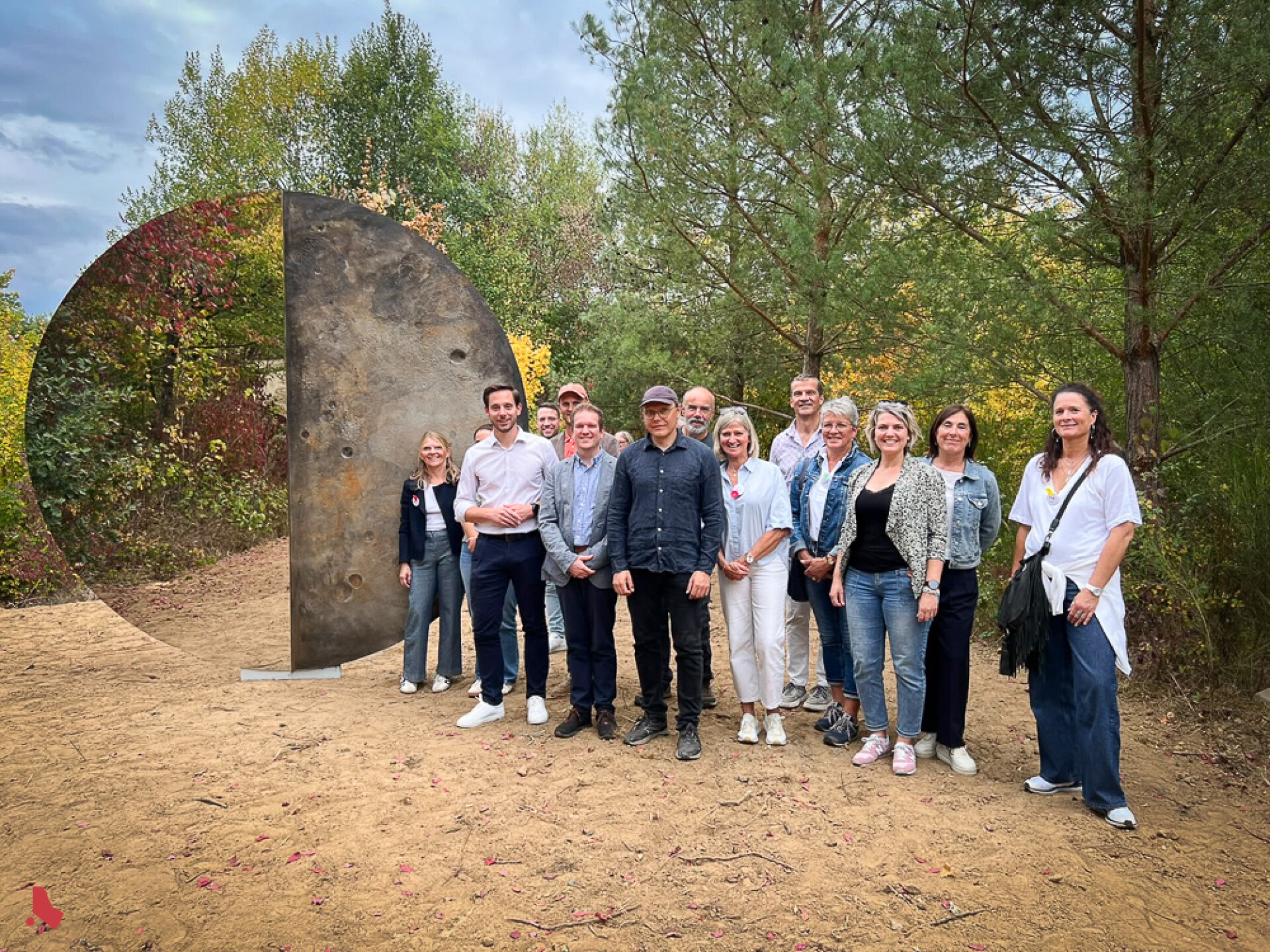 Photo de groupe à côté de la sculpture « Transformation », mi-miroir, mi-métal, au Mirador « Op der Berk »