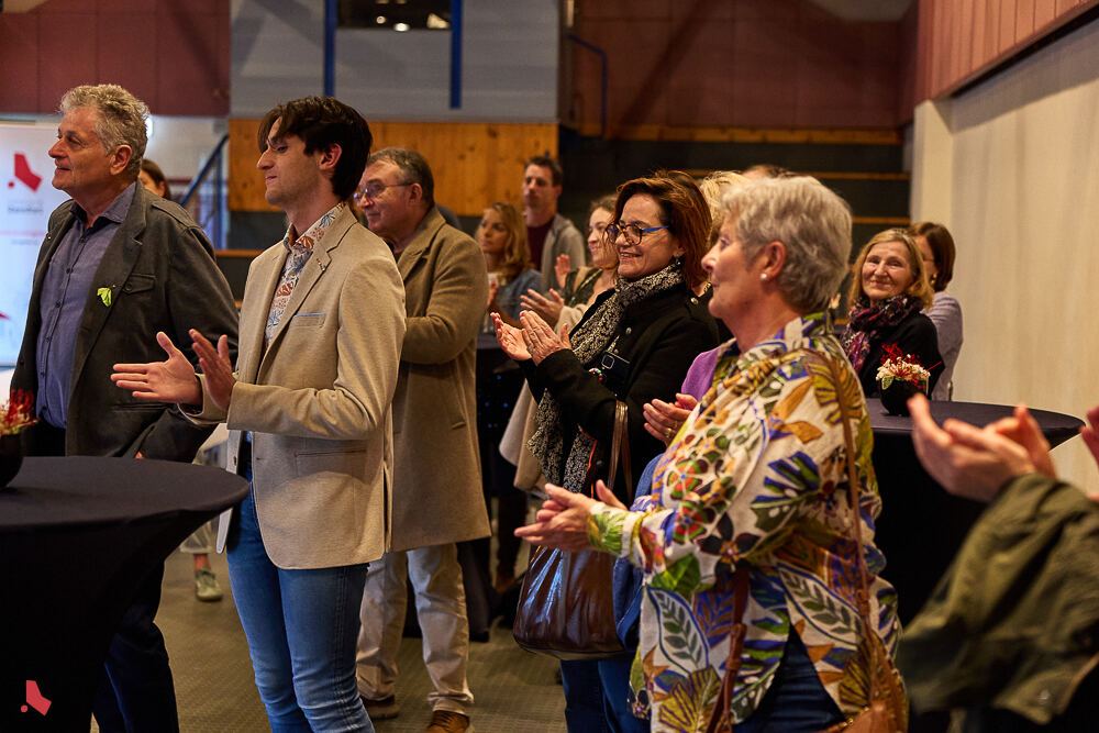 Des invité·e·s souriant·e·s applaudissent chaleureusement lors de la cérémonie