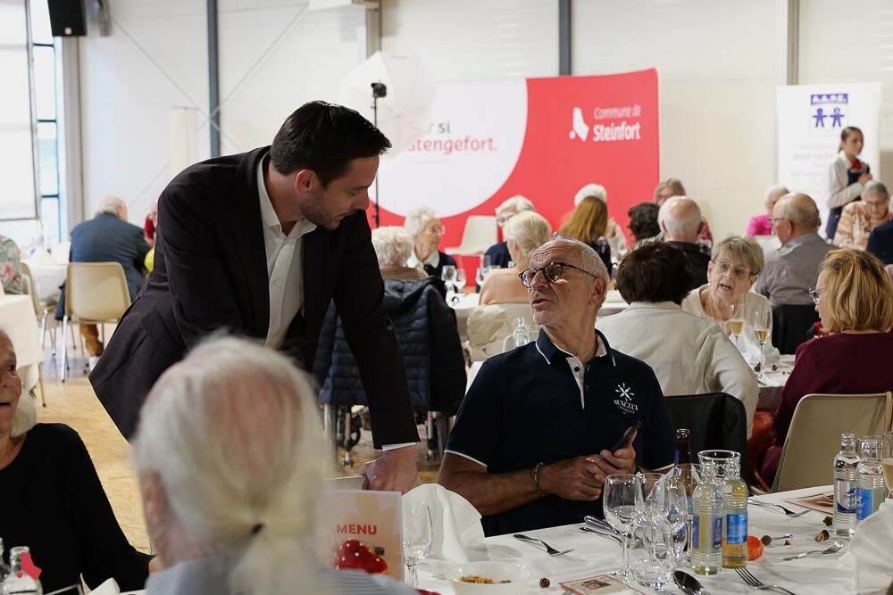 Sammy Wagner échange avec un invité attablé lors de la Hierschtmatinée au centre culturel Keeseminnen