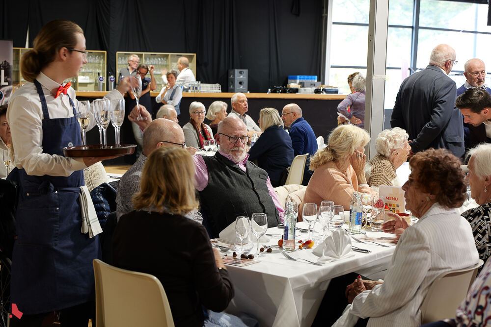 Une serveuse apporte des verres aux invité·e·s attablé·e·s lors de la Hierschtmatinée