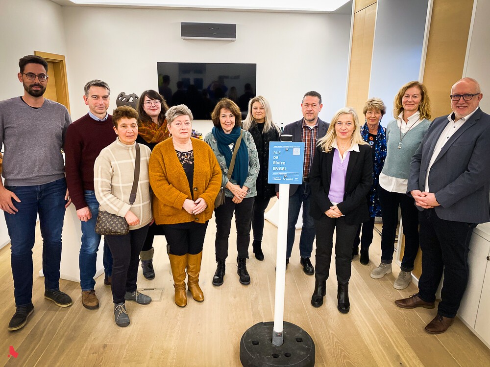 Photo de groupe autour du panneau « Rue Dr Elvire Engel » du projet « Rues au féminin »
