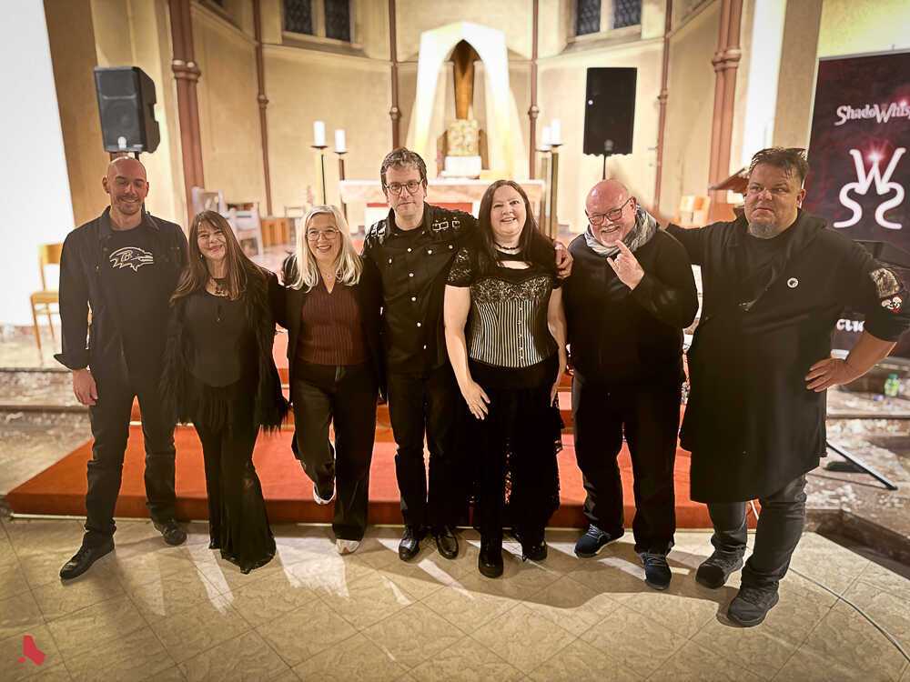 Photo de groupe des musicien·ne·s et organisateur·rice·s devant le chœur, après le concert « Metal & Pipes »