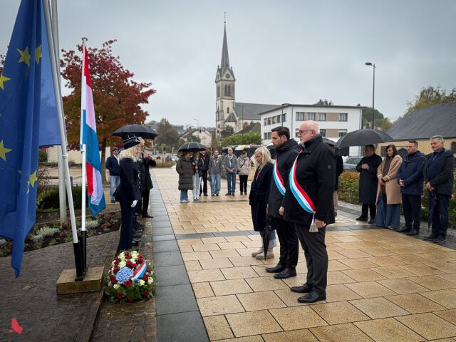 Des élu·e·s se recueillent devant une gerbe au Square Patton, sous la pluie, lors de la Journée de commémoration nationale