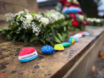 Pierres du souvenir peintes alignées sur le monument aux morts, dont l’une porte l’inscription « Erënnerung »