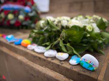 Pierre du souvenir représentant la Terre entourée de personnages qui se tiennent la main, sur le monument aux morts